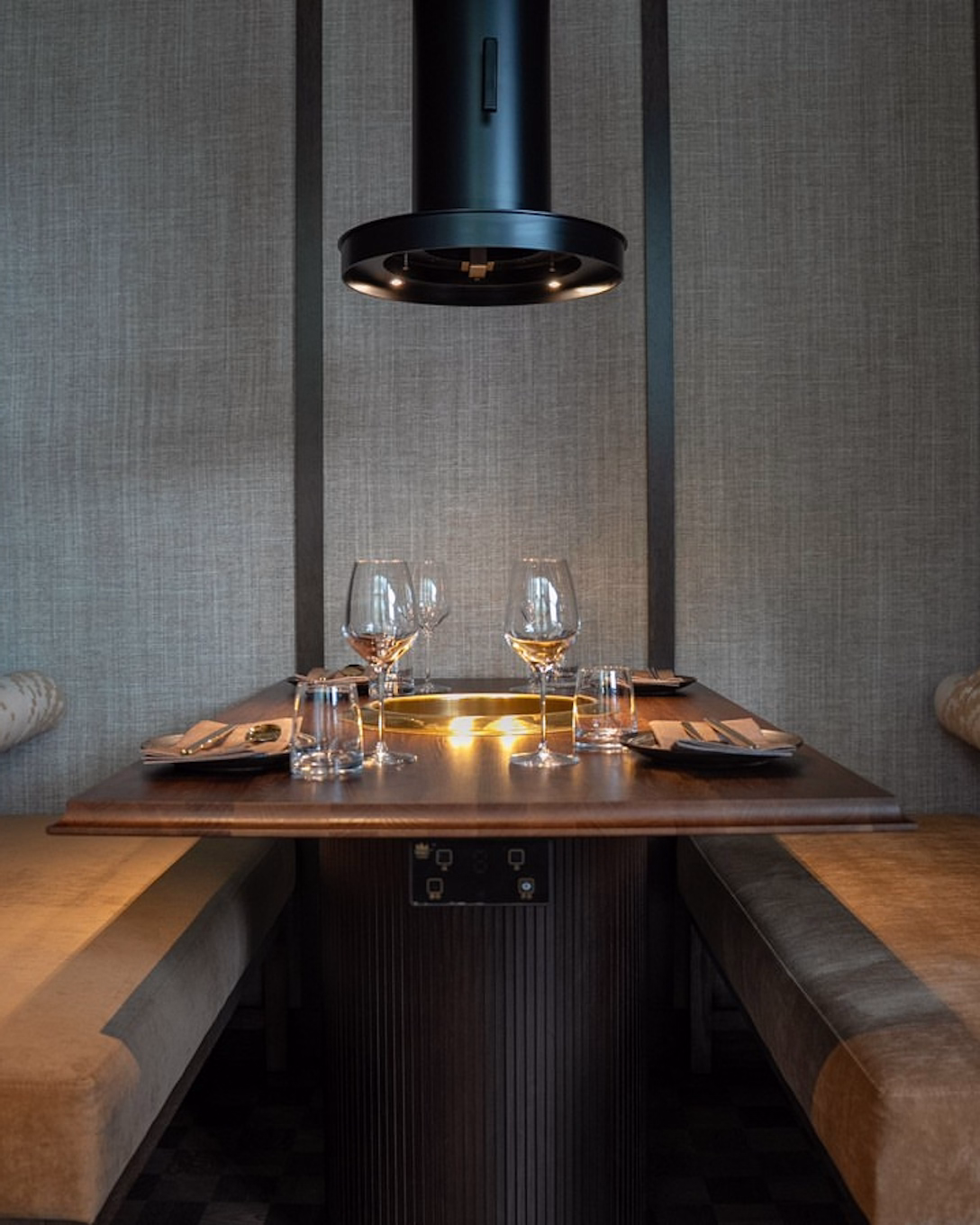A table with a built-in grill and overhead extractor at Chingu BBQ & Sojubar in Stockholm